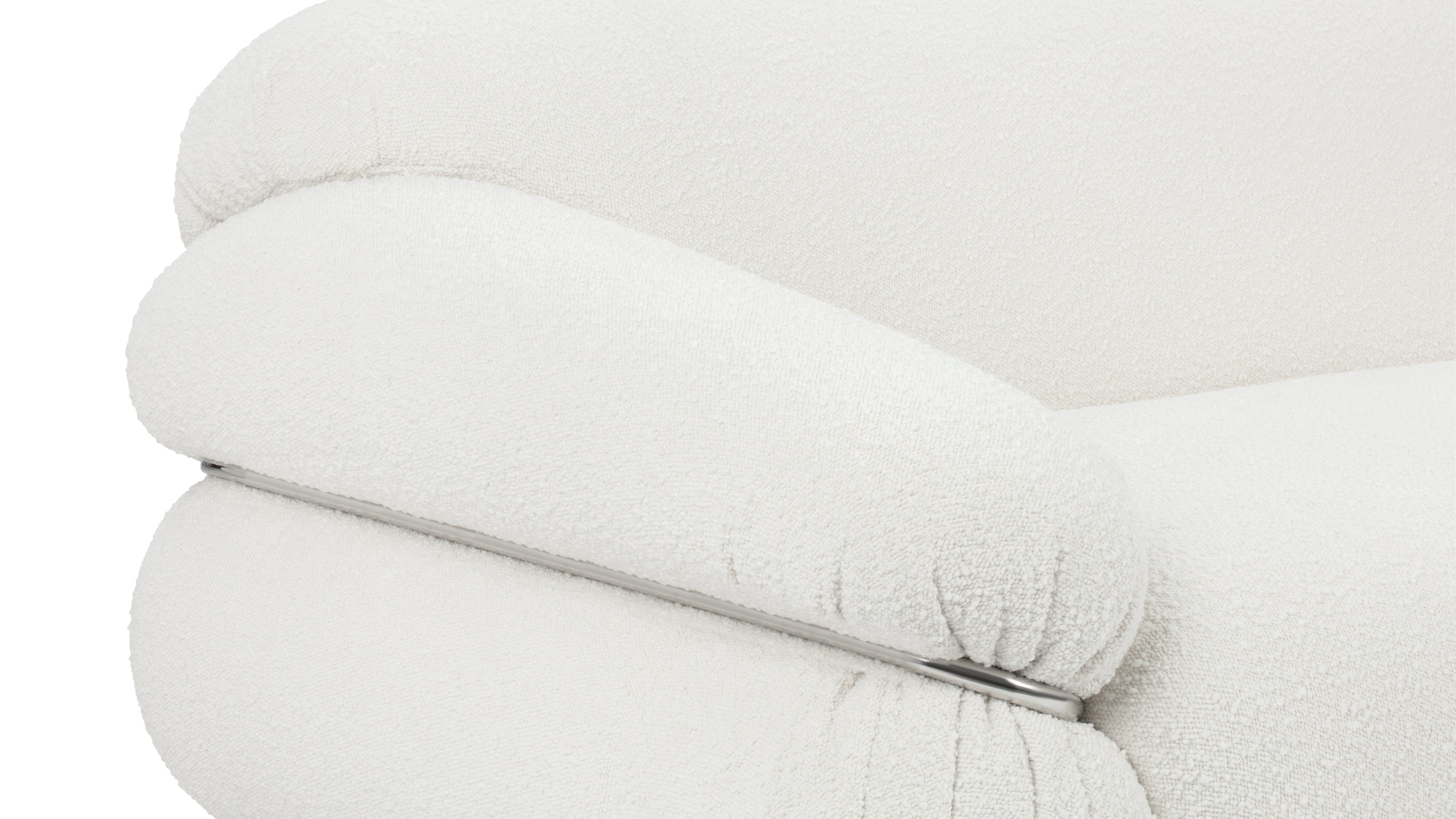 Detail of the Sesann Sofa's polished stainless steel frame and white boucle upholstery