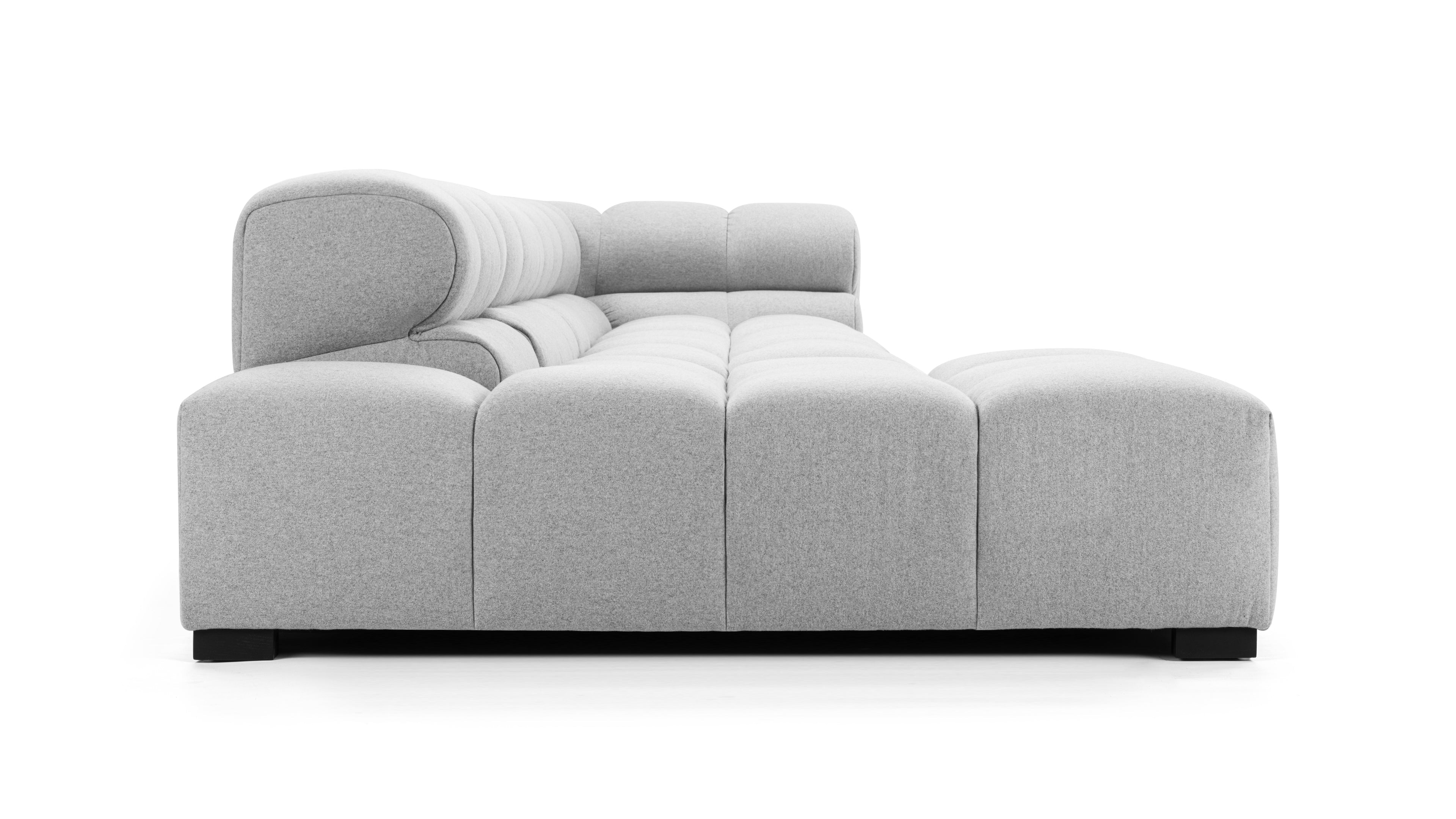 Plush light gray tufted sectional in a living room set, providing both style and comfort to the modern home.