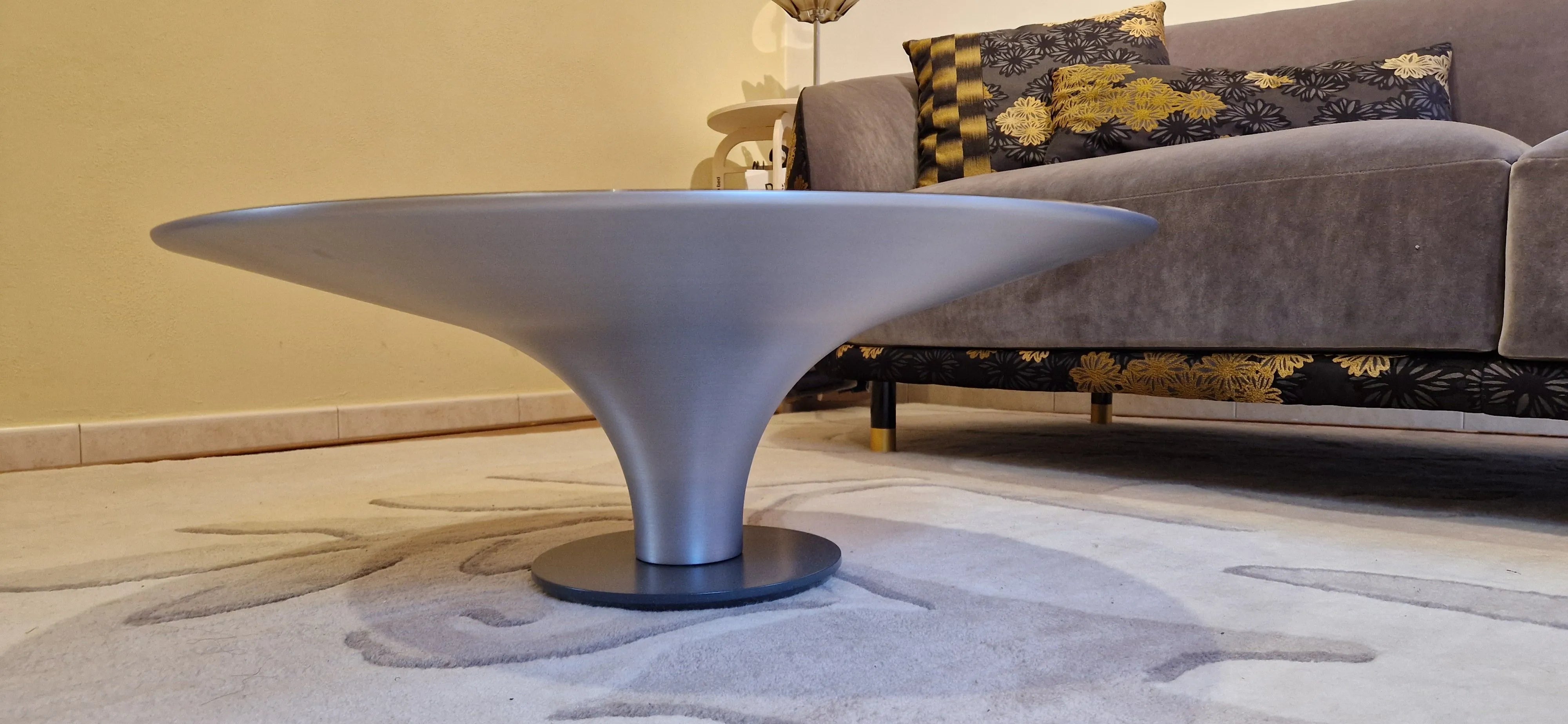 Designer Ovni Up table, combining sleek contours with a lacquered steel base